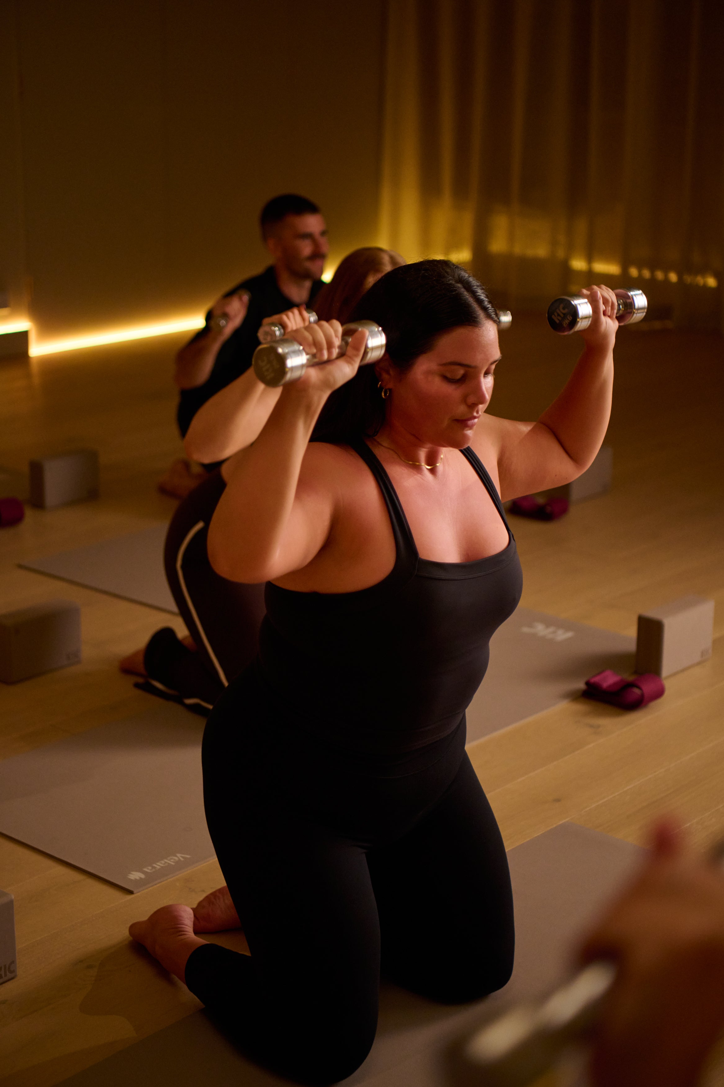 Woman exercising with dumbbells in a KICStudio Power class