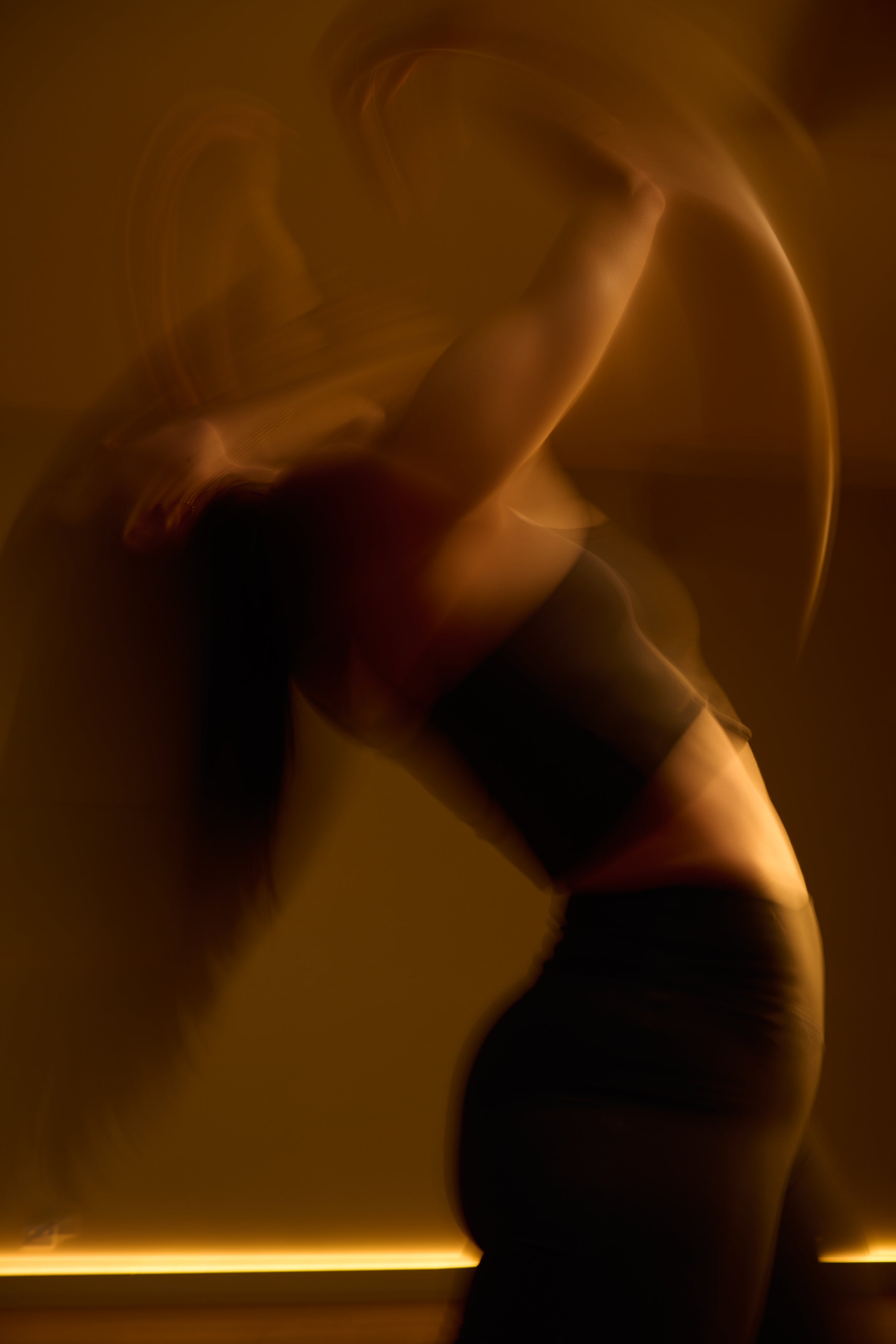 Silhouette of a person moving in KICStudio class with a warm glow