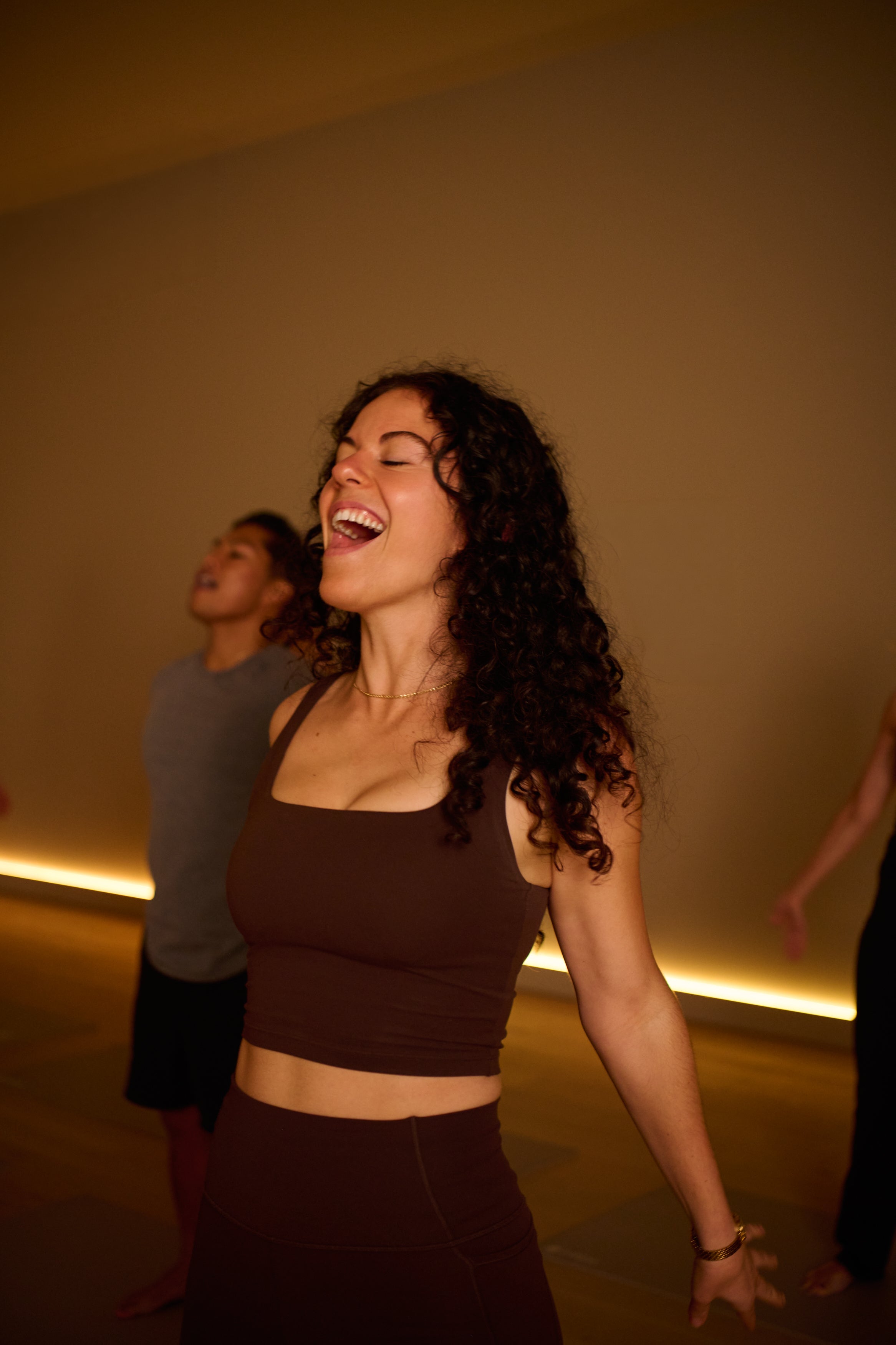 Woman exhaling with a warm glow in a KICStudio class with people around