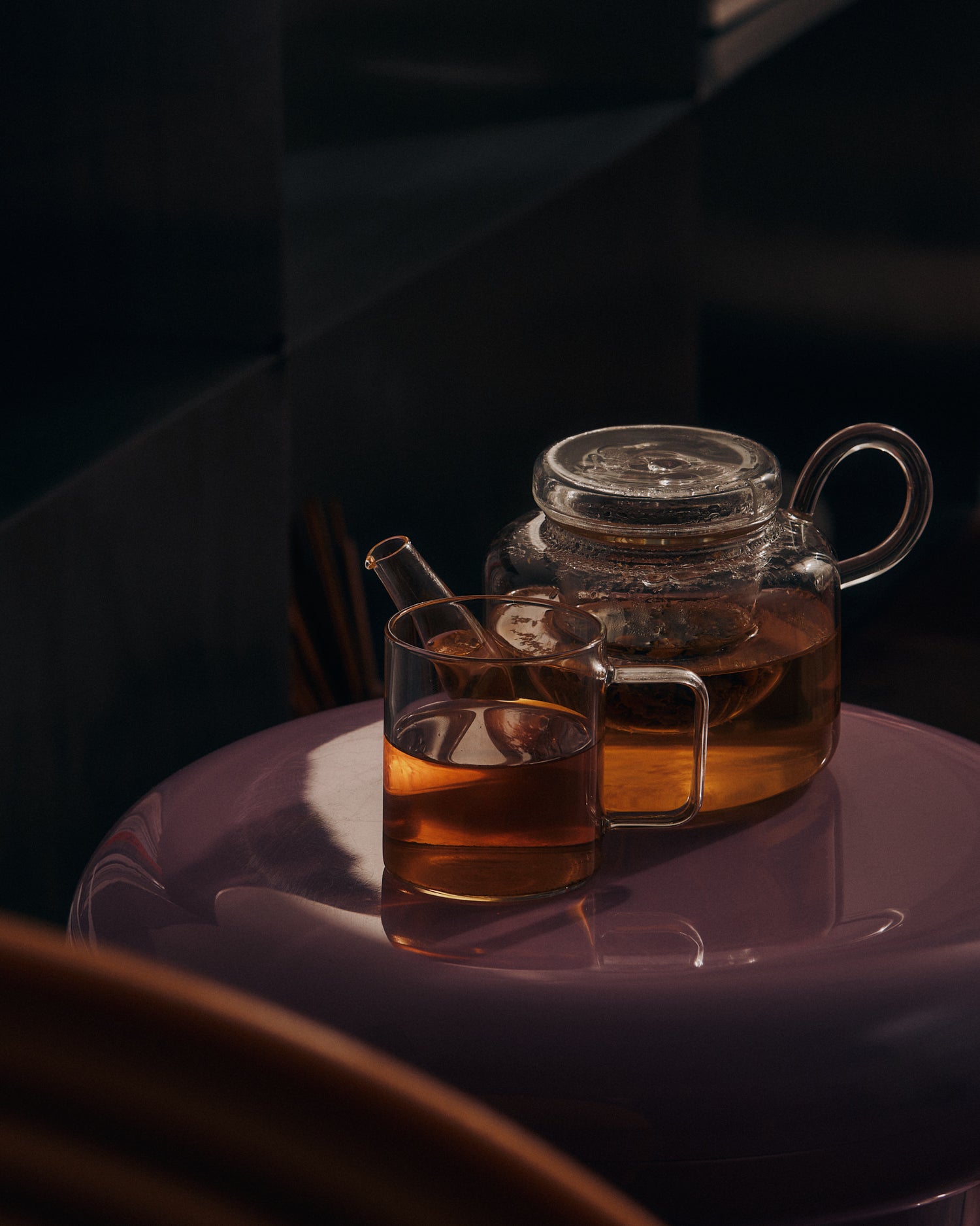 KIC herbal tea in a glass teapot and cup on a side table