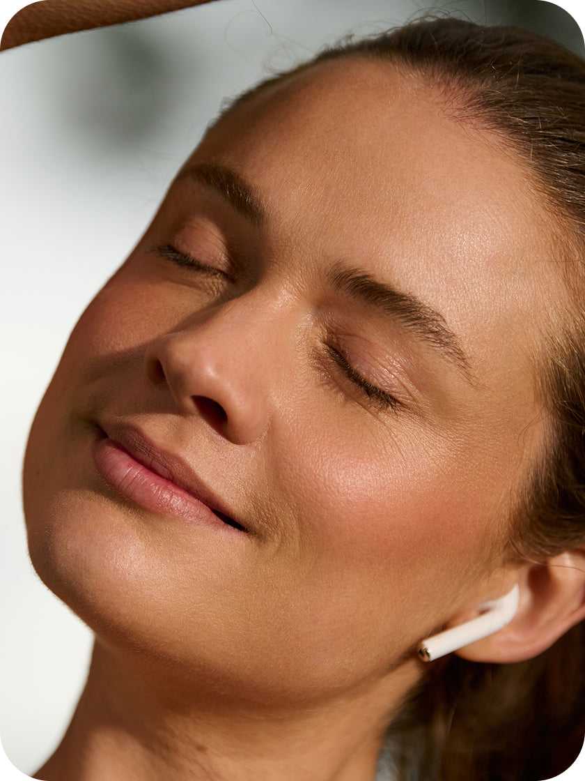 Close-up of a person wearing earphones with a neutral background
