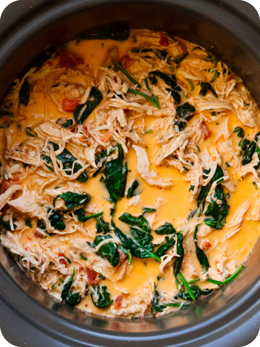 Slow cooker with chicken, spinach, and cheese mixture